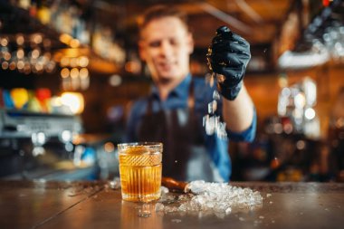 Önlük erkek barmen çalışıyor buz ile barda sayaç. Alkol içecek hazırlama. Barmen işgal