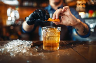 Erkek barmen ekler turuncu deri barda alkollü bir içecek için sayaç. Barmen meslek, iş yerinde profesyonel barmen