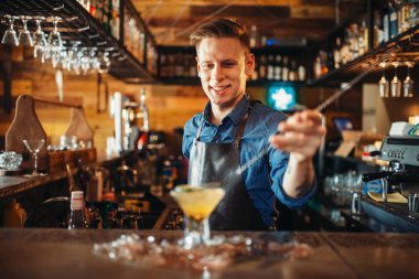 Erkek barmen buz ile alkollü kokteyl hazırlar. Barmen meslek, barmen Bar counter
