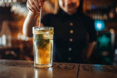 Kadın barmen bir bardakta içki karıştırın. Barda karıştırma kadın barmen sayaç pub. Barmen işgal