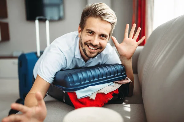 Smiling Man Lies Overloaded Suitcase Overflowing Overloaded Suitcase Fees Journey — Stock Photo, Image