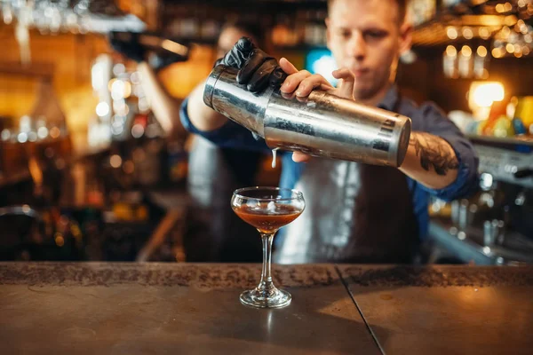 男性バーテンダーがバーでシェーカーから飲み物を注いでカウンター アルコール カクテルの準備 バーテンダーの職業 バーテンダー — ストック写真