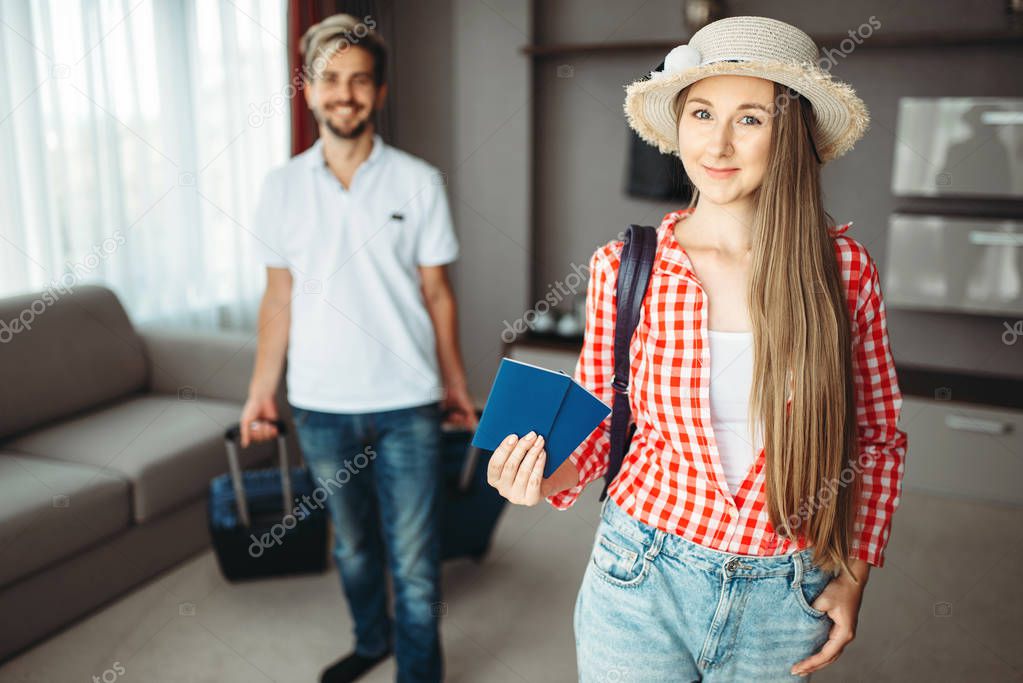 Young couple with suitcases went on a journey. Woman holding tickets