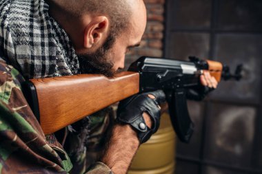Tek tip bir Kalaşnikof tüfek closeup amaçlayan, silah ile erkek mujahiddeen acımasız terörist. Terörizm ve terör kavramı