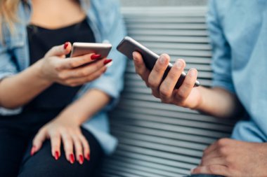 Telefon bağımlılığı, bankta oturan ve akıllı telefonlar üzerinde seyir çift, sosyal insan bağımlısı bağımlı