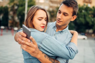 Telefon bağımlılık, bağımlı adam hugs kadın ve onun aygıtı bu zaman, sosyal bağımlısı insanlar, modern ilişki arıyor