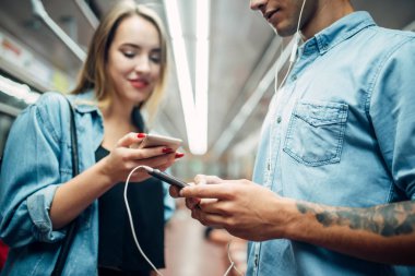 Genç bir çift metro araba, bağımlılığı sorunu, sosyal bağımlısı insanlar, modern Metro yaşam tarzı içinde telefon kullanma