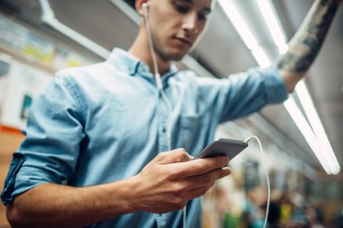 Metro, bağımlılığı sorunu, sosyal bağımlısı insanlar, modern Metro yaşam tarzı içinde telefon kullanan genç adam