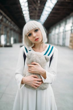 Anime tarzı sarışın kız teddy bear sarılmak. Kadın, Japon Kültür cosplay, terk edilmiş ve fabrika oyuncak bebek