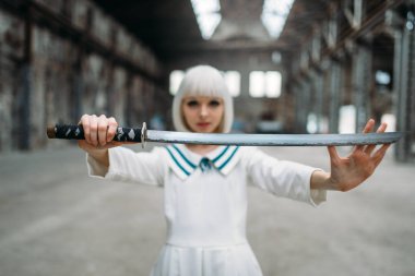 Güzel anime tarzı sarışın kadın kılıçla. Moda, Asya kültürü cosplay, bez bebek terk edilmiş ve fabrika blade, makyaj ile sevimli kadın ile