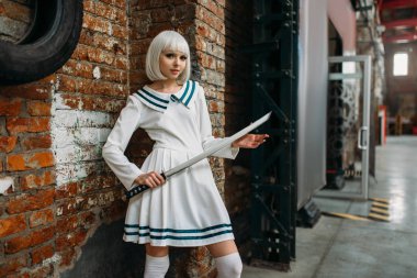 Seksi anime tarzı sarışın Bayan kılıç ile. Cosplay moda, Asya kültürü, bıçak bebekle, şirin makyaj fabrika dükkanda kadınla