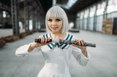 Güzel anime tarzı sarışın Bayan kılıç ile. Cosplay moda, Asya kültürü, bıçak bebekle, şirin makyaj fabrika dükkanda kadınla