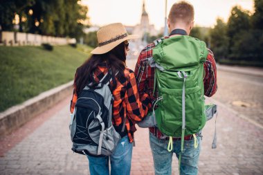 Yürüyüşçüler gezi turist kasabasında, arkadan görünüm üzerinde sırt çantaları ile. Hiking yaz. Macera genç erkek ve kadın zammı