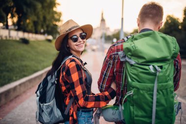 Yürüyüşçüler gezi turist kasabasında, arkadan görünüm üzerinde sırt çantaları ile. Hiking yaz. Macera genç erkek ve kadın zammı