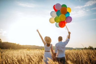 Çift eğlence günbatımı çavdar alanda balonları, tr. Güzel karı ve koca yaz çayır üzerinde yürüme