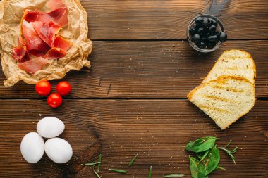 Baharat, zeytin, ot, ekmek ve yumurta üzerinde ahşap masa, üstten görünüm, çiğ et kimse. Pişmemiş taze beefstek, gıda hazırlama, pişirme