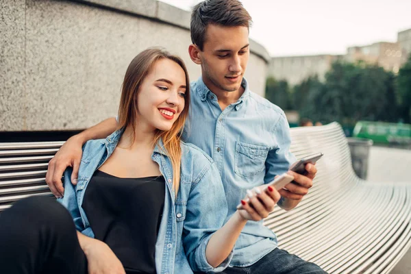 电话成瘾 吸毒成瘾夫妇的肖像使用智能手机在公园的长凳上 社会成瘾的人 — 图库照片