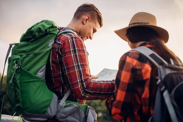 ハイカーのバックパックとは マップ 観光の町で遠足に見えます 夏のハイキング 若い男と女の冒険をハイキングします — ストック写真