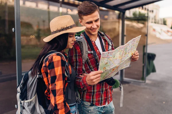 バス停でのカップルは 観光の町の観光都市の観光スポットの地図を勉強します 夏のハイキング 若い男と女の冒険をハイキングします — ストック写真