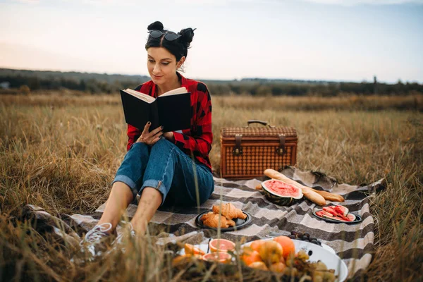 Giovane Donna Seduta Sul Plaid Legge Libro Picnic Nel Campo — Foto Stock