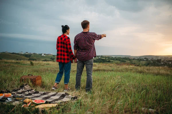 距離は フィールドでのピクニックに探している若いカップル ロマンチックな視察旅行 男と女で屋外のお食事 — ストック写真