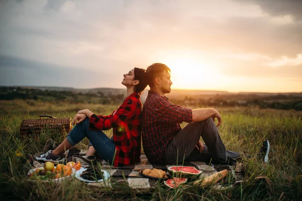 フィールドでの日没 ピクニックに互いに背を向けて座って愛のカップル 屋外ディナー 幸せな家族の週末日没男女のロマンチックな視察旅行 — ストック写真