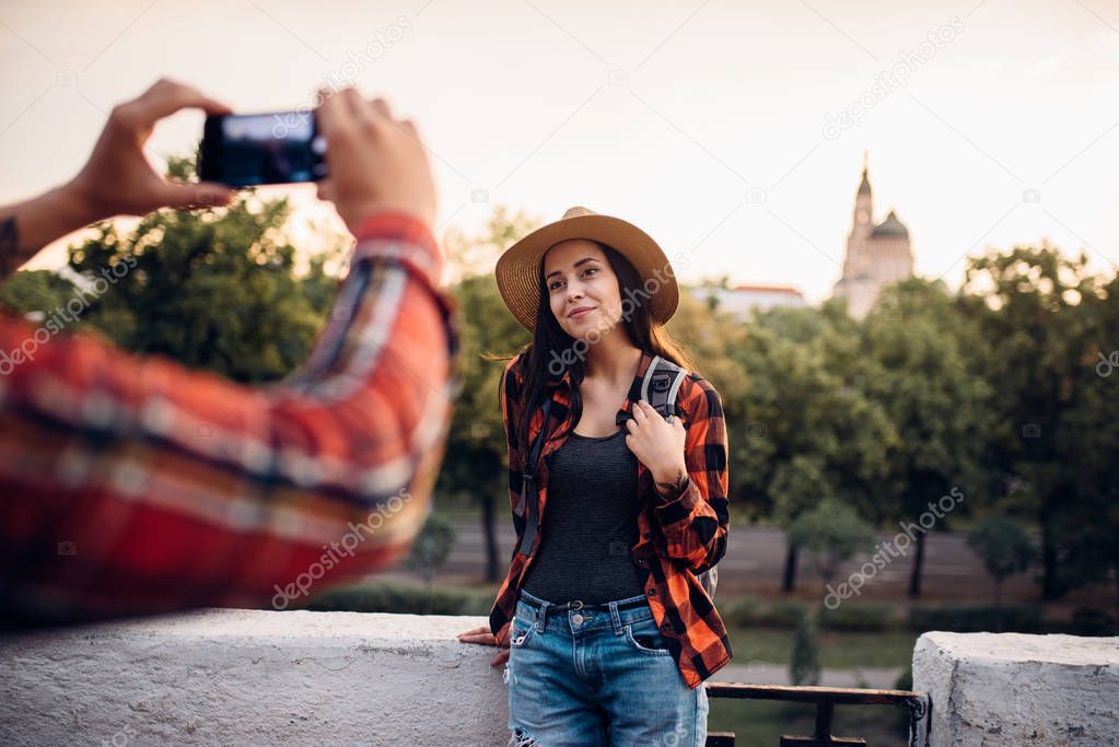 Young woman poses on excursion in tourist town. Summer hiking of love couple. Hike adventure of young man and woman