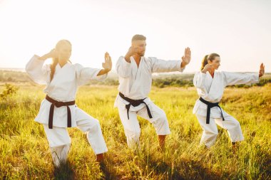 kadın savaşçıları ile yaz alanında erkek ana karate eğitim. Savaş sanatı egzersiz açık, teknik uygulama