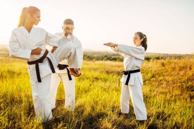 Ana kadın karate savaşçıları tekme zaman doğru stand öğretir. Savaş sanatı egzersiz açık, teknik uygulama