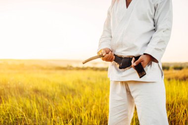 Siyah kemer ile beyaz kimono, yaz alan arka plan üzerinde erkek karate dövüşçü. Savaş sanatı eğitim açık
