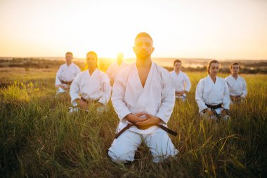 Karate yere oturma grubu ve derin derin düşünür, yaz alanında eğitim. Doğada açık, gevşeme egzersiz dövüş sanatları okulu