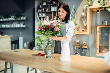 Kadın çiçekçi çiçek bir buket çiçek dükkanında yapmak için seçer. Floristik Servisi, bitki iş
