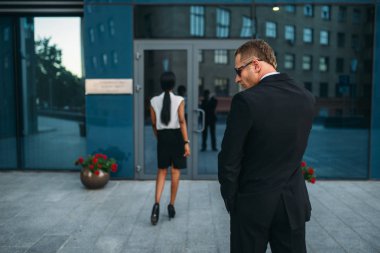 Kişisel koruma güneş gözlüğü ve güvenlik kulaklık, arkadan görünüm, arka plan üzerinde siyah bir iş kadını. Koruma riskli bir meslektir, VIP koruma, koruma