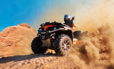 Arka plan üzerinde dört kiralama toz bulutları, kum ocağında. Atv çöl dunes içinde kask içinde erkek sürücü