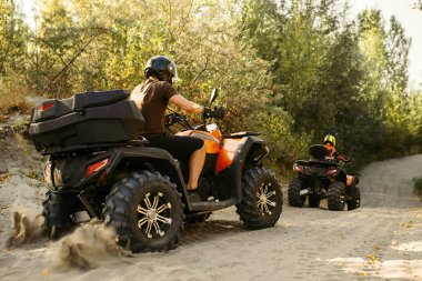 Kask içinde iki quad bisiklet bisikletçi ormanda, önden görünüm yayılıyor. ATV üzerinde aşırı spor sürme ve seyahat, quadbike macera