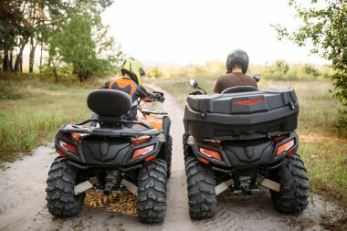Kask, arkadan görünüm iki atv bisikletçi. Serbest sürüşte quad bisiklet, aşırı spor ve seyahat, quadbike yaz macera