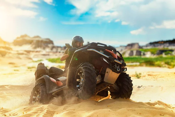 砂の採石場 極端なスポーツの Atv フリーライディング 砂場でクワッド自転車に乗ってヘルメットの男性ドライバー — ストック写真