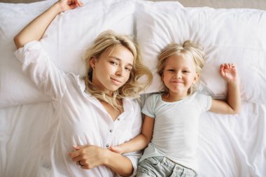 Görünümü en neşeli anne ve çocuk evde, yatakta yatıyordu. Duygu ebeveyn, beraberlik, mutlu kez