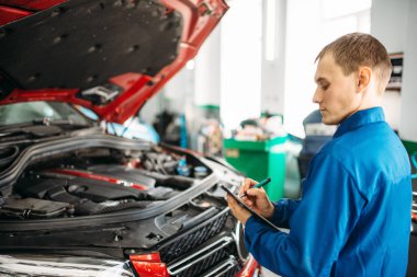 Not defteri ile teknisyen sorunlarını giderme kontrol listesi, araba ile açılan kukuleta, doldurur. Otomobil Servisi, araç bakım