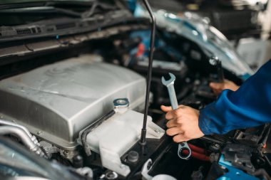 Erkek teknisyen araba motoru ile çalışır. Otomatik-servis, araç bakım, tamirci araçları ile