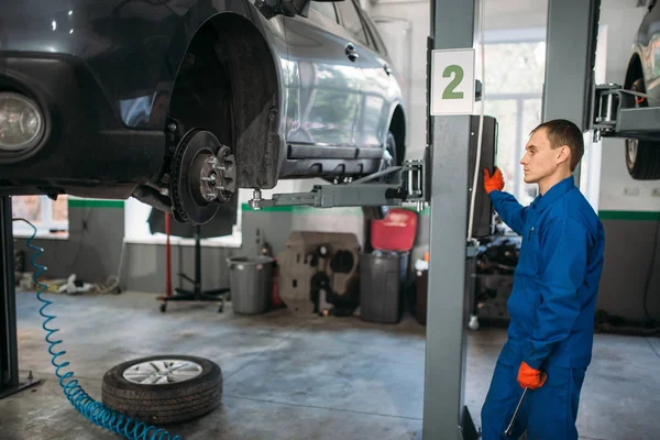 Mechanic Wrench Hands Looks Car Lift Tire Service Vehicle Maintenance — Stock Photo, Image