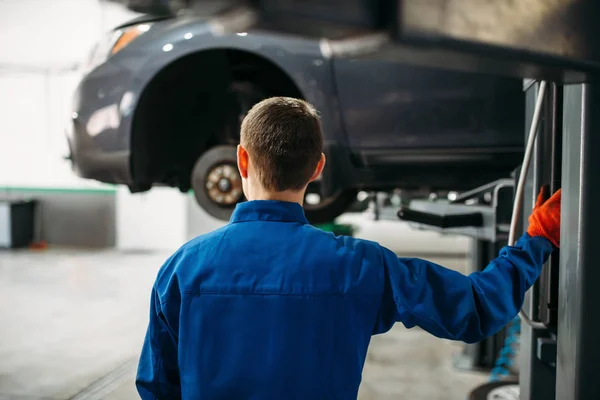 Mechanic Wrench Hands Looks Car Lift Tire Service Vehicle Maintenance — Stock Photo, Image