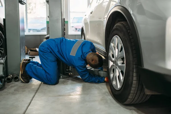 Mechanik Mundurze Dostosowuje Lift Jack Zawieszenie Diagnostyczne Naprawa Samochodów Samochodowe — Zdjęcie stockowe