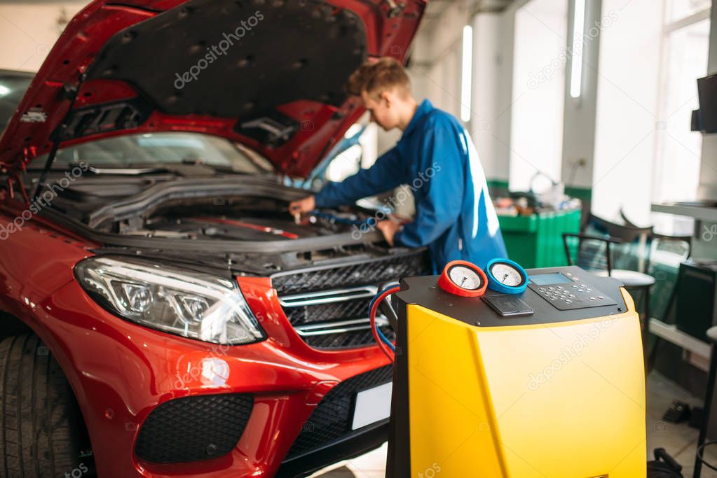 Mechanic connects air conditioning system for diagnosis of freon. Conditioner diagnostic