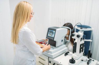 Bilgisayar tanılama vizyon, gözlük profesyonel seçimi. Gözlükçü kabine içinde muayenesinden. Hasta ve Doktor, göz bakım danışmanlık, gözlük diyoptri seçimi