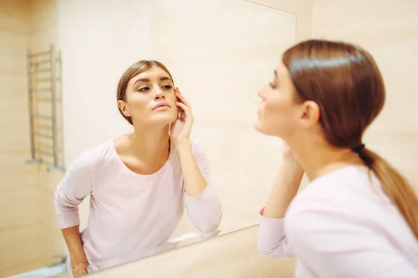 年轻女子看着浴室里的镜子 女性人关心皮肤 早晨面部清洁程序 — 图库照片