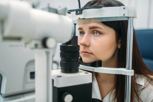 Young female patient on eyesight test in optician cabinet, diagnostic of vision, professional choice of glasses lens. Consultation with specialist, ophthalmology