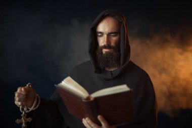 Kilise, Gizli ritüel elinde kitap ile dua ortaçağ keşiş. Karanlık pelerinli gizemli rahip. Gizem ve Maneviyat