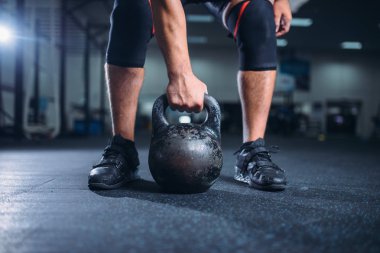 Güçlü erkek atlet kettlebell kaldırma ile egzersiz için hazırlar. Spor ve fitness kulübü, ağırlık çalışan eğitim salonunda halter egzersiz