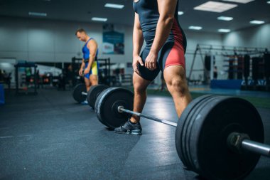 Egzersiz spor salonu iç arka plan üzerinde Barbell ile iki güçlü halterci. Halter egzersiz fitness Club, vücut geliştirme